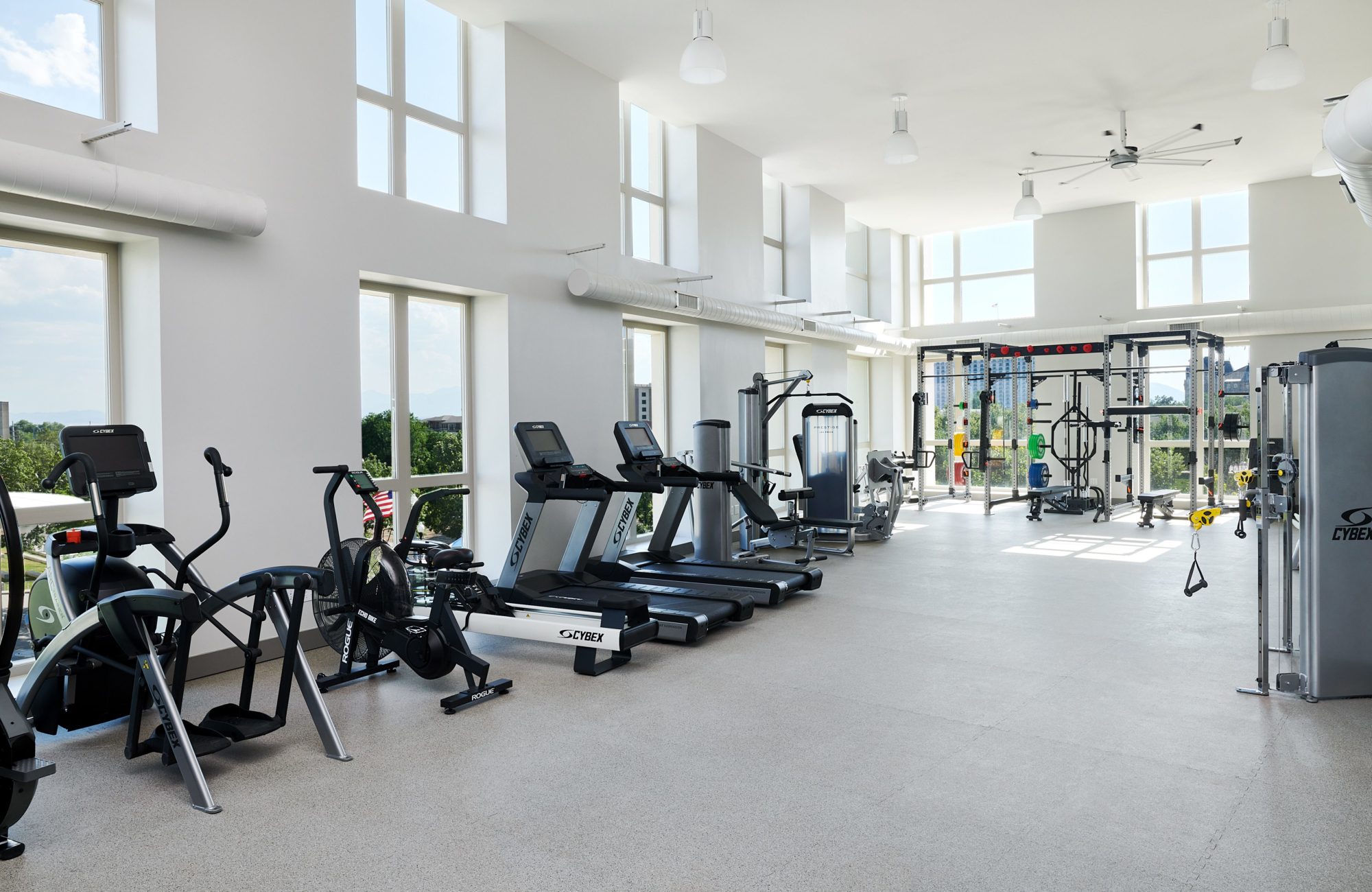 Spacious fitness center with bright lighting and fully stocked weights and cardio machines