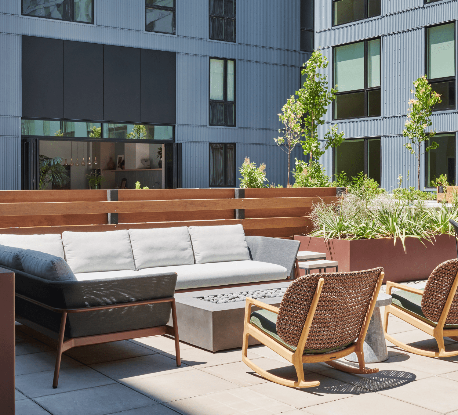 Courtyard patio with cushioned seating, rocking chairs, and firepit