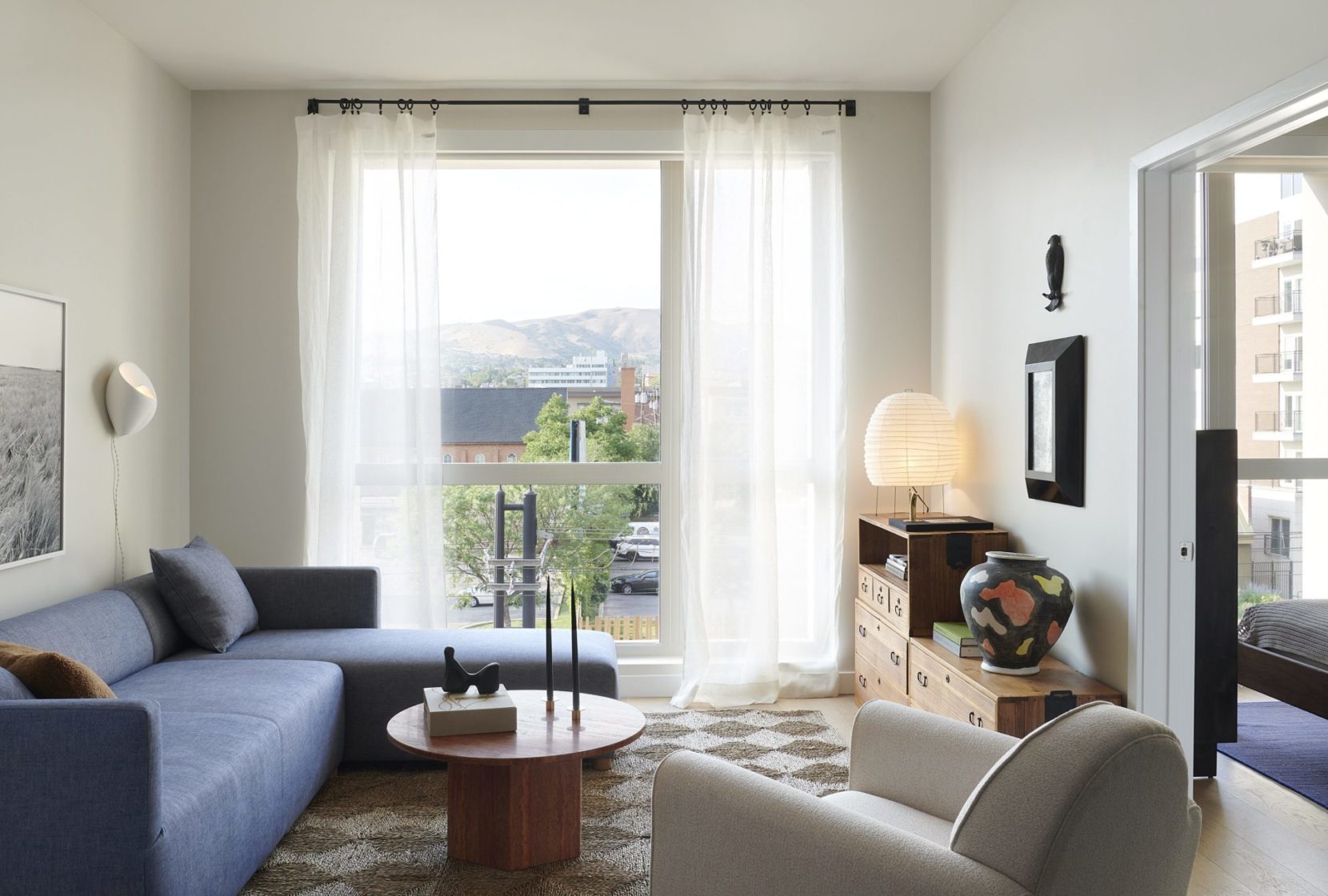 Living room at AVia with sectional, floor-to-ceilign window and stylish furniture